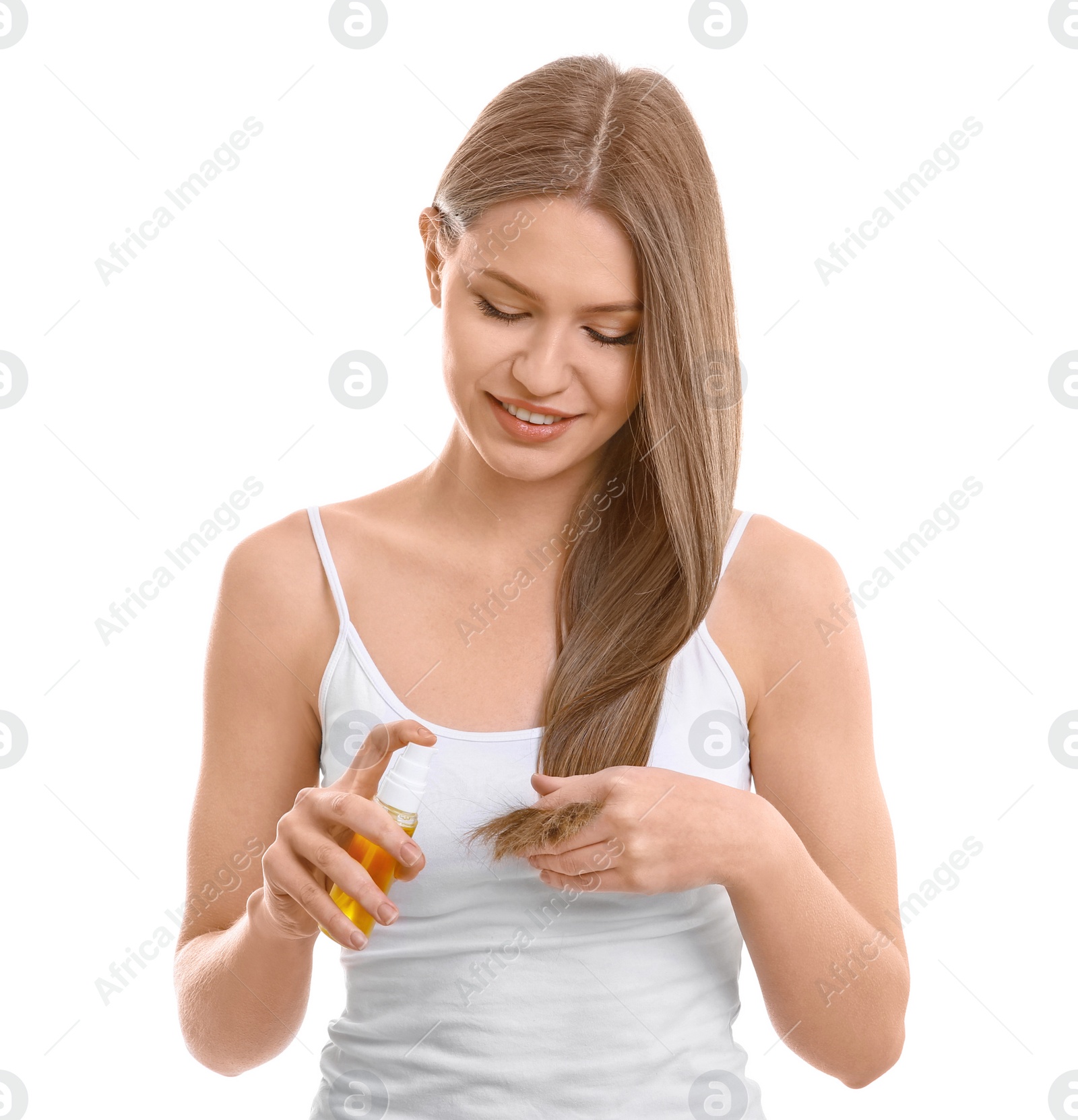 Photo of Young woman applying oil onto hair on white background