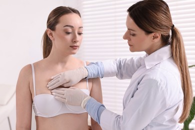 Mammologist checking young woman's breast in hospital