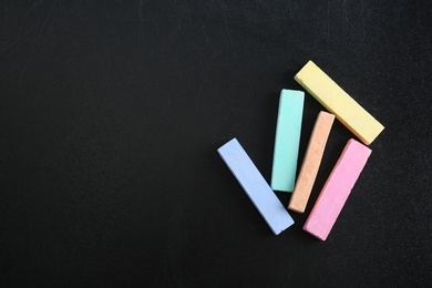 Color pieces of chalk on blackboard, top view