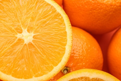 Photo of Cut and whole fresh ripe oranges as background, top view