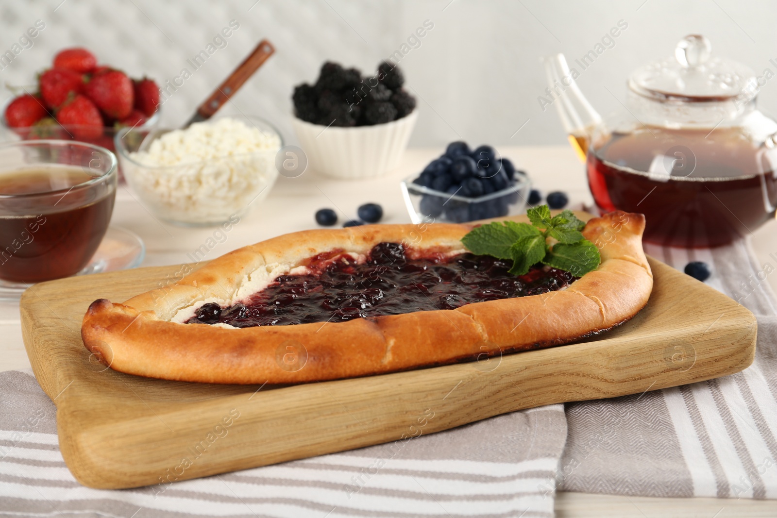 Photo of Delicious sweet cottage cheese pastry with cherry jam served on table