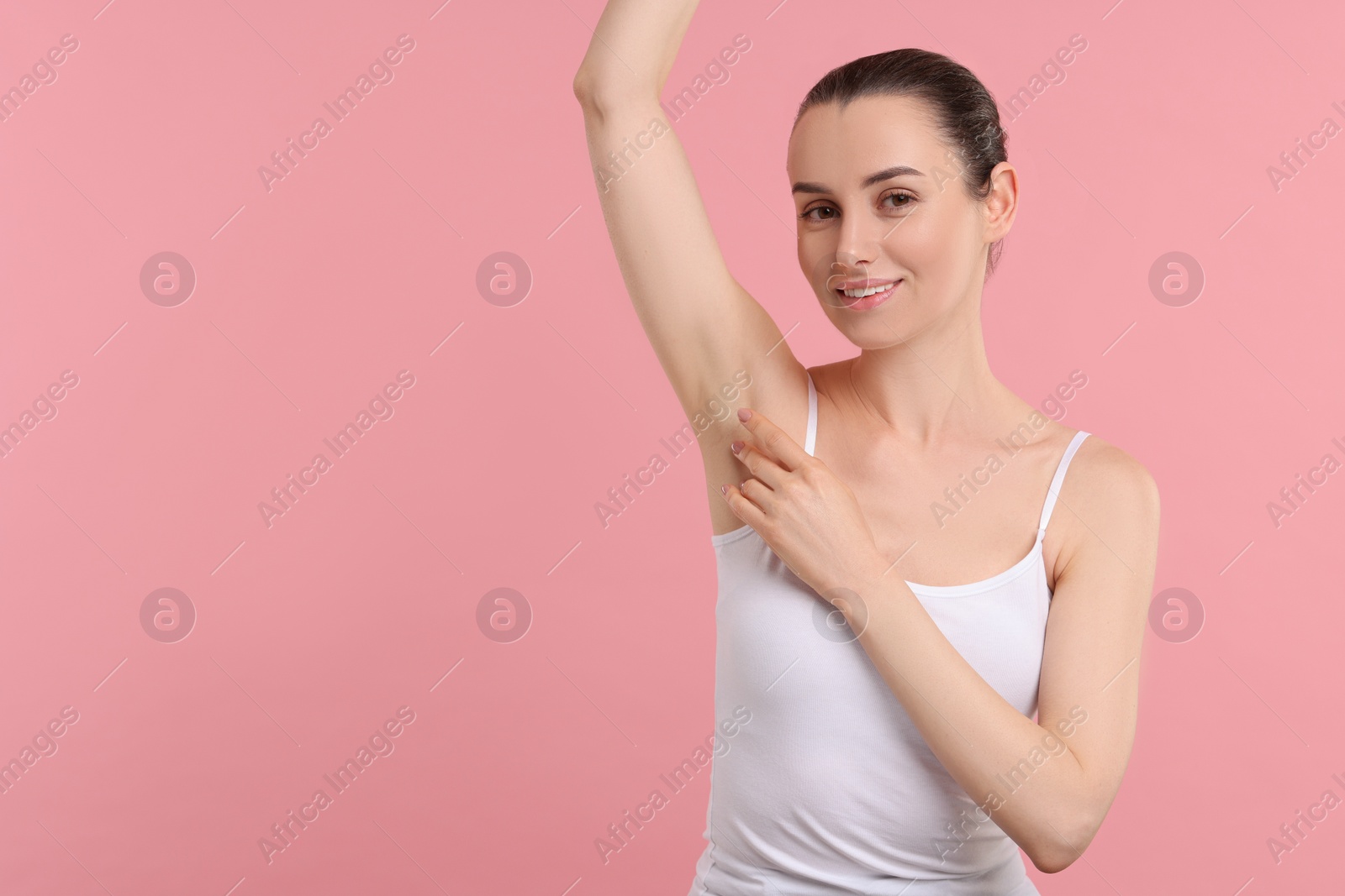 Photo of Beautiful woman showing armpit with smooth clean skin on pink background, space for text