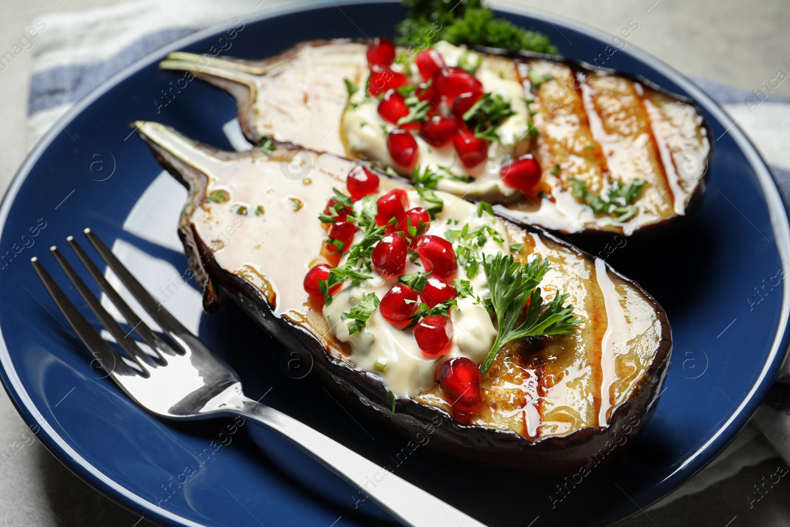 Photo of Plate with tasty fried eggplants on gray table