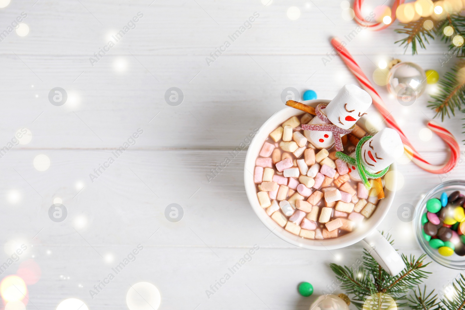 Image of Flat lay composition with marshmallow snowmen in cup of hot drink on white wooden table, space for text. Bokeh effect 