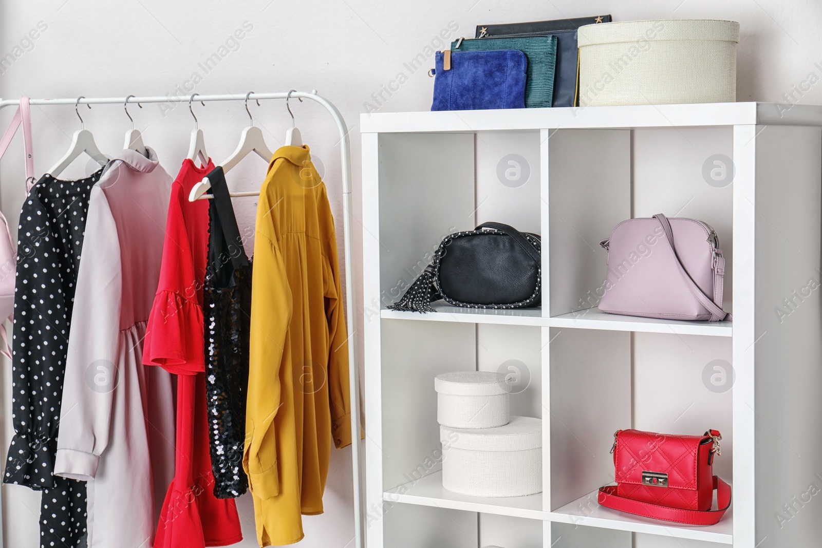 Photo of Wardrobe with stylish bags and clothes indoors. Idea for interior design