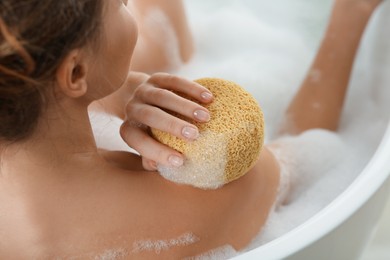 Photo of Woman with sponge taking bubble bath, closeup