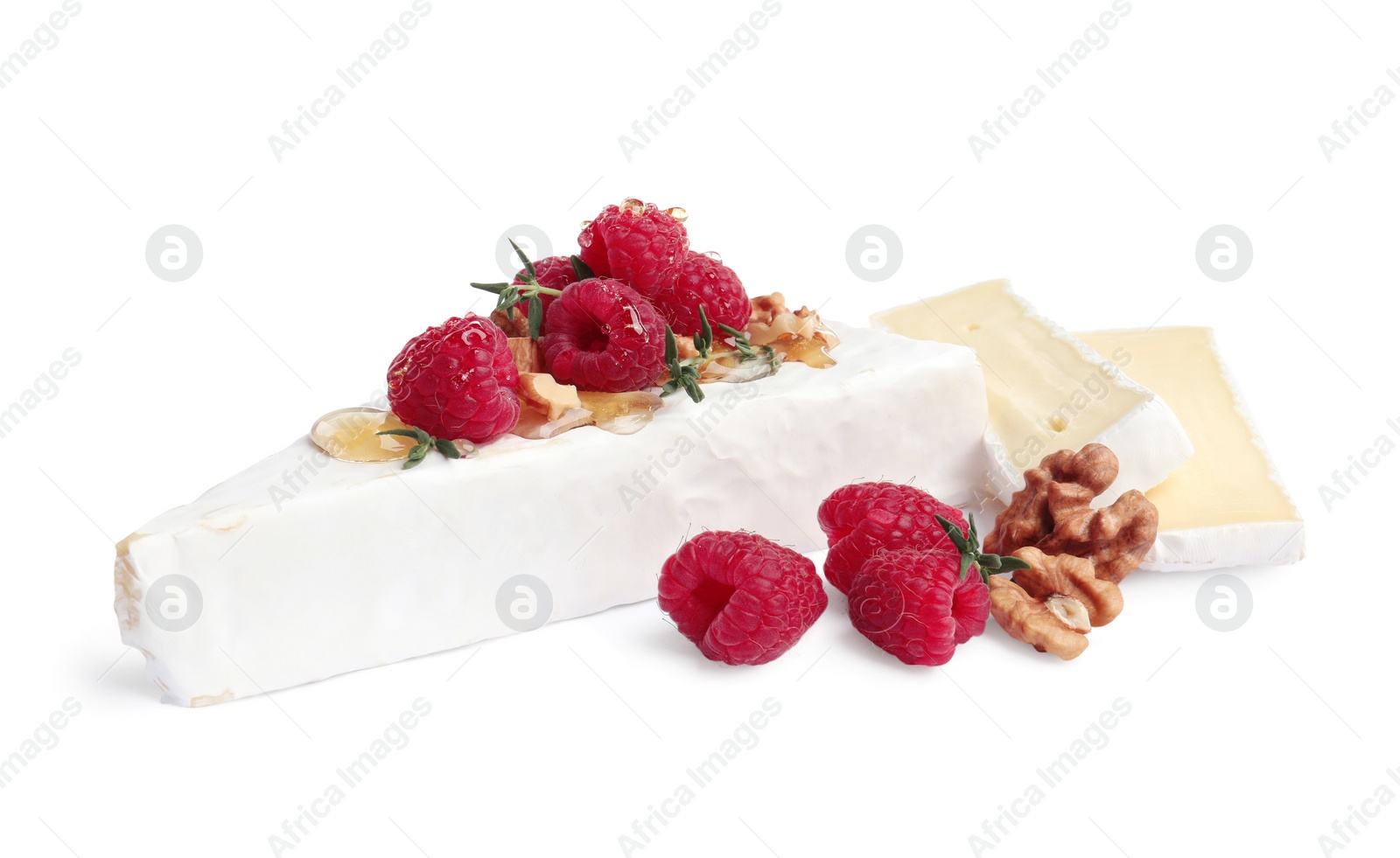 Photo of Brie cheese served with honey, raspberries and walnuts isolated on white