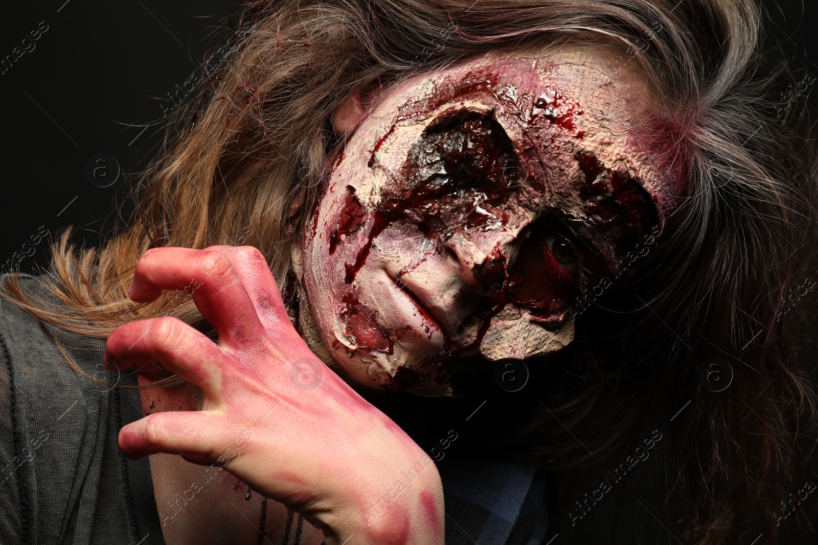 Photo of Scary zombie on dark background, closeup. Halloween monster