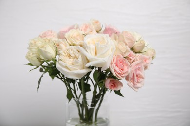 Beautiful rose flowers in vase on white background, closeup