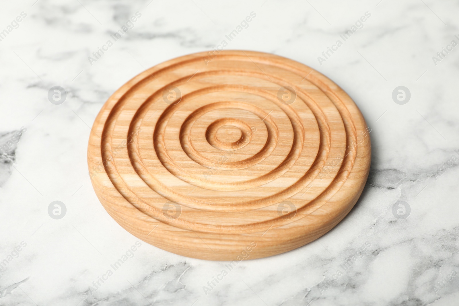 Photo of Stylish wooden cup coaster on white marble table, closeup