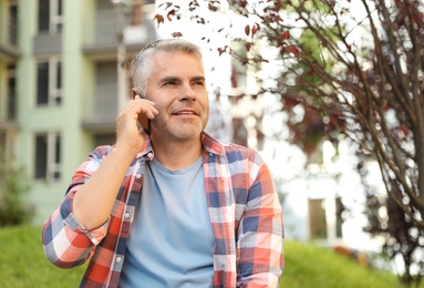 Photo of Handsome mature man talking on phone in park