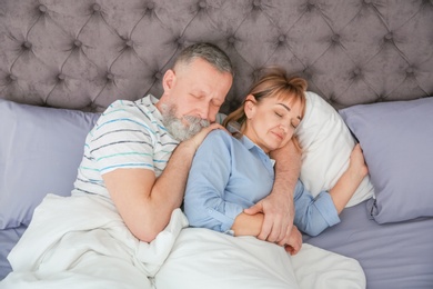 Photo of Mature couple together in bed at home