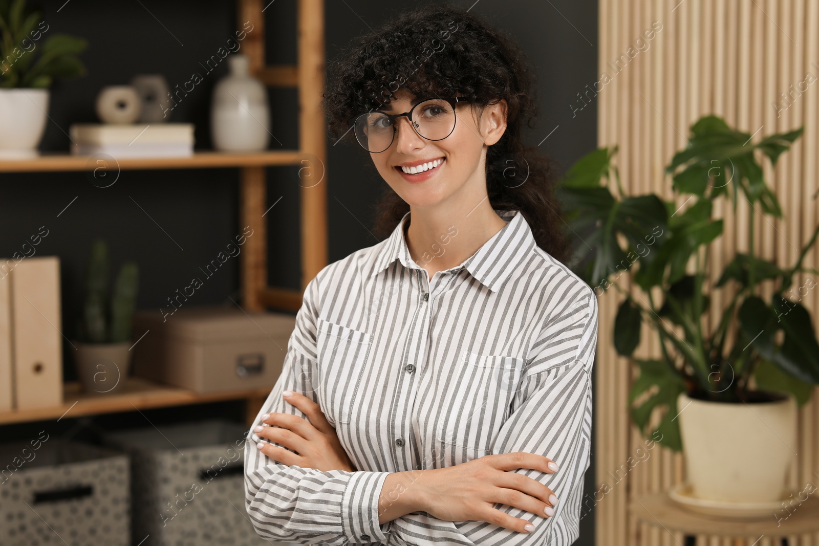 Photo of Portrait of beautiful woman with curly hair indoors. Attractive lady smiling and looking into camera