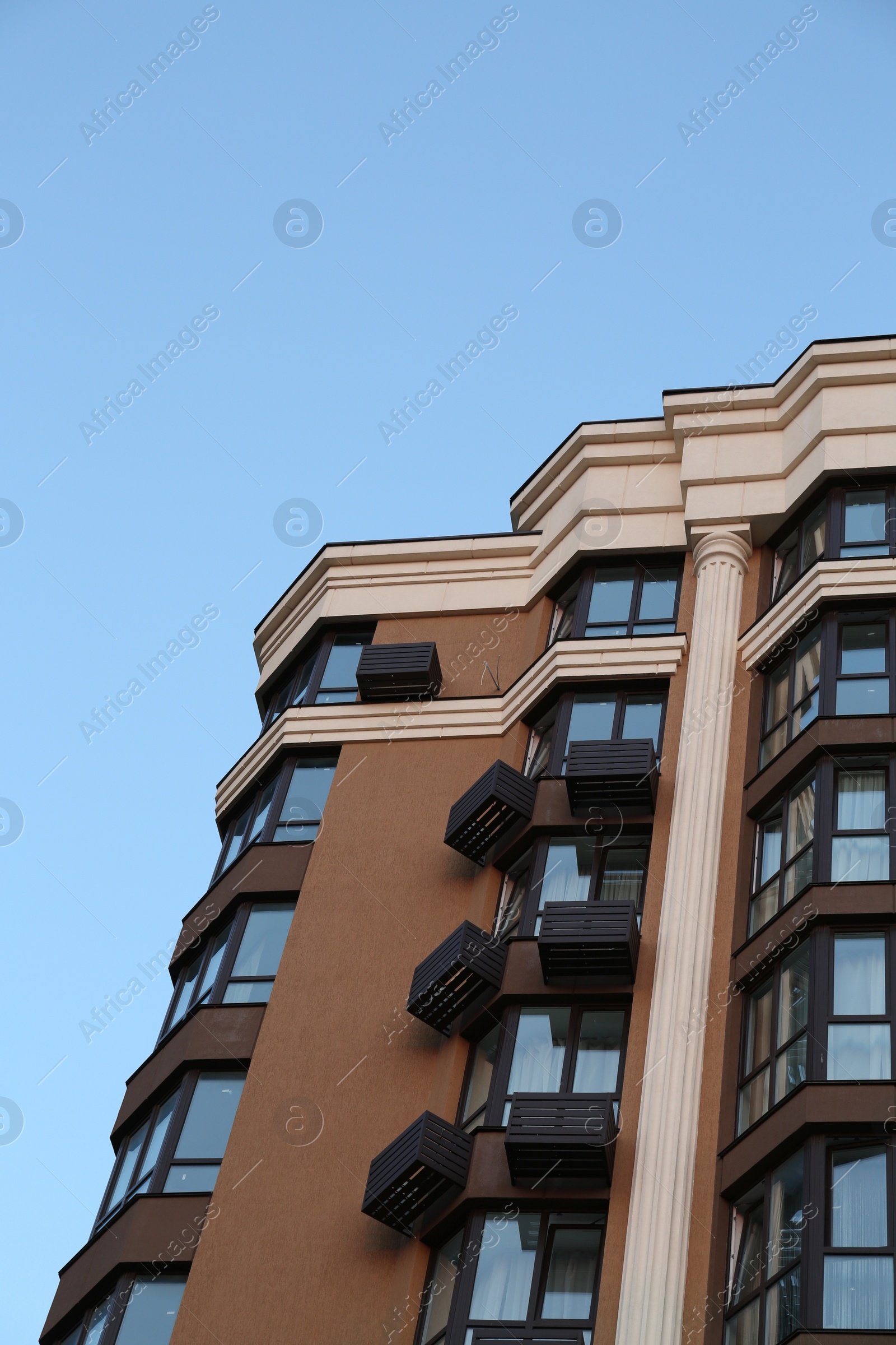 Photo of Facade of beautiful residential building against blue sky, low angle view