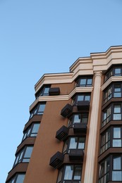 Facade of beautiful residential building against blue sky, low angle view