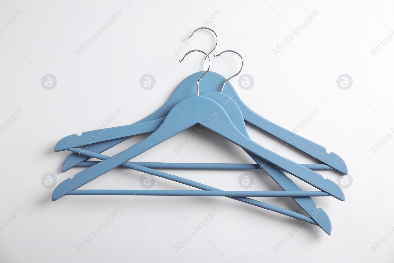 Photo of Empty clothes hangers on white background, top view