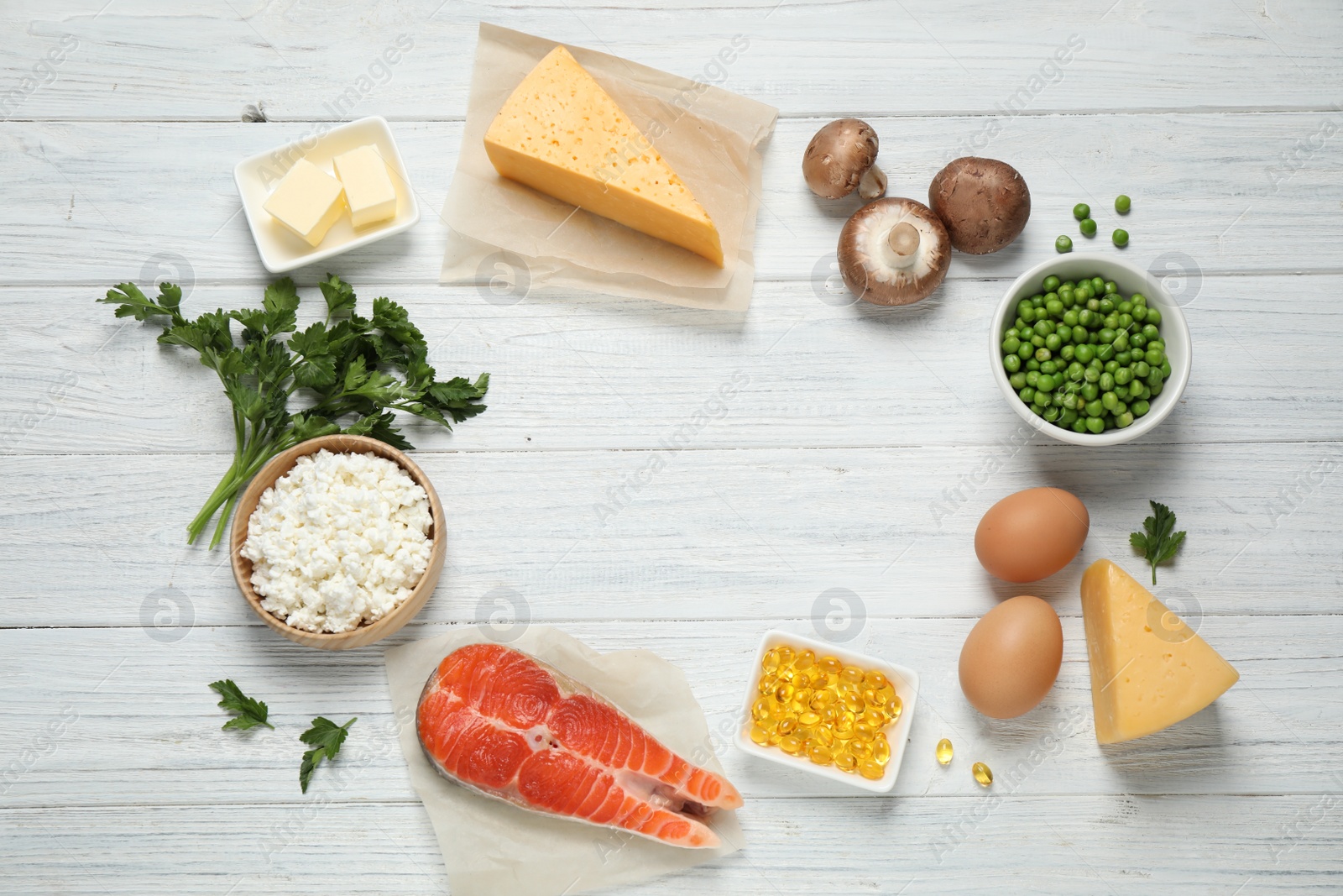 Photo of Flat lay composition with products rich in vitamin D on white wooden table. Space for text