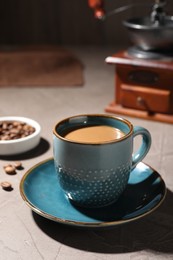 Photo of Delicious coffee with milk in cup on light textured table, closeup