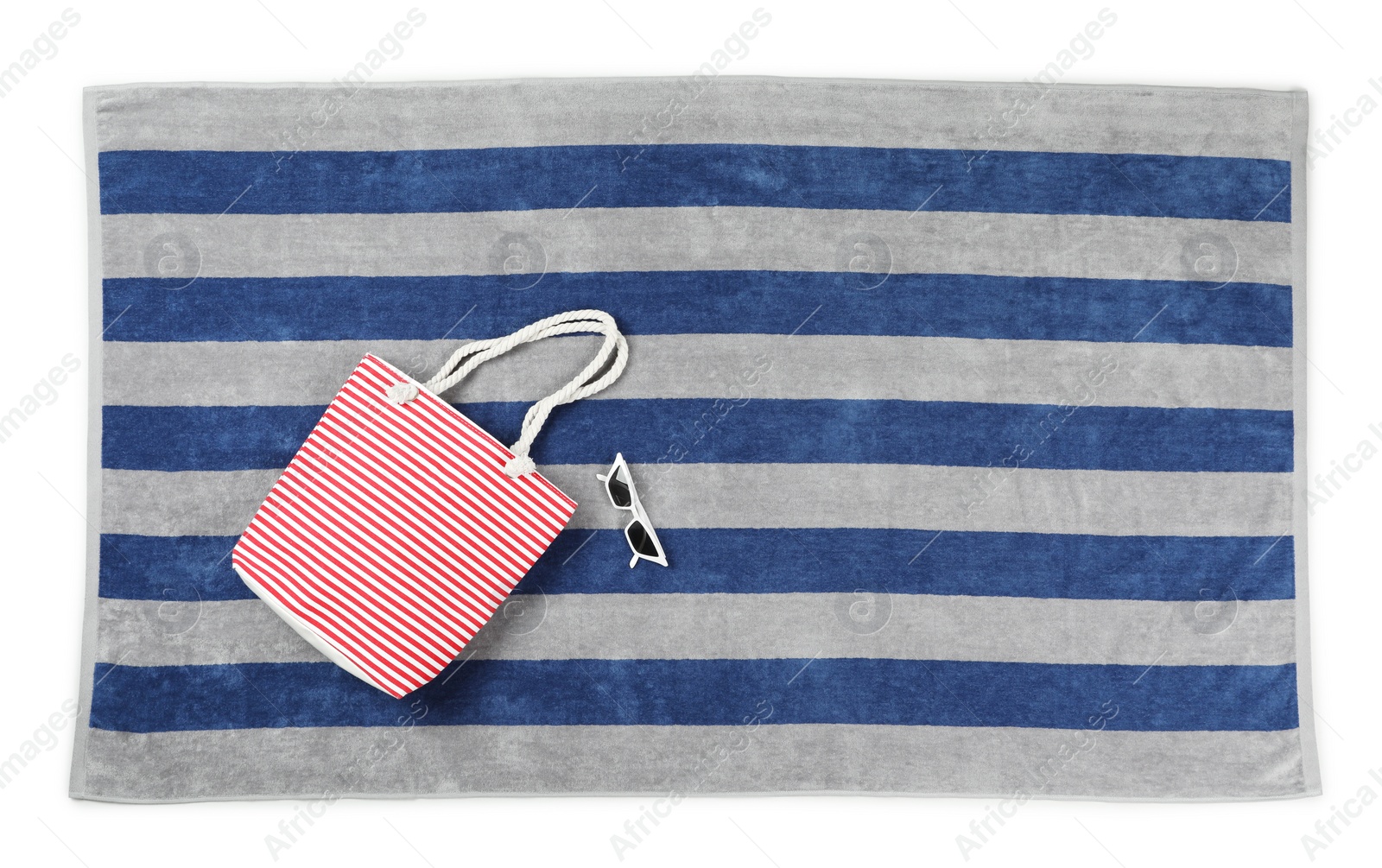 Photo of Striped beach towel with bag and sunglasses on white background, top view