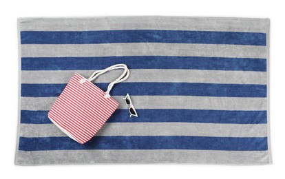 Photo of Striped beach towel with bag and sunglasses on white background, top view