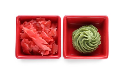 Photo of Bowls with swirl of wasabi paste and pickled ginger on white background, top view