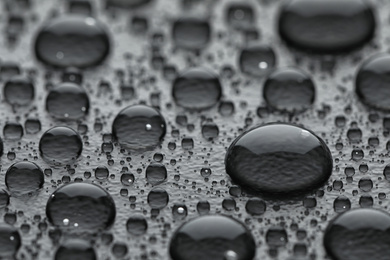 Water drops on grey background, closeup view