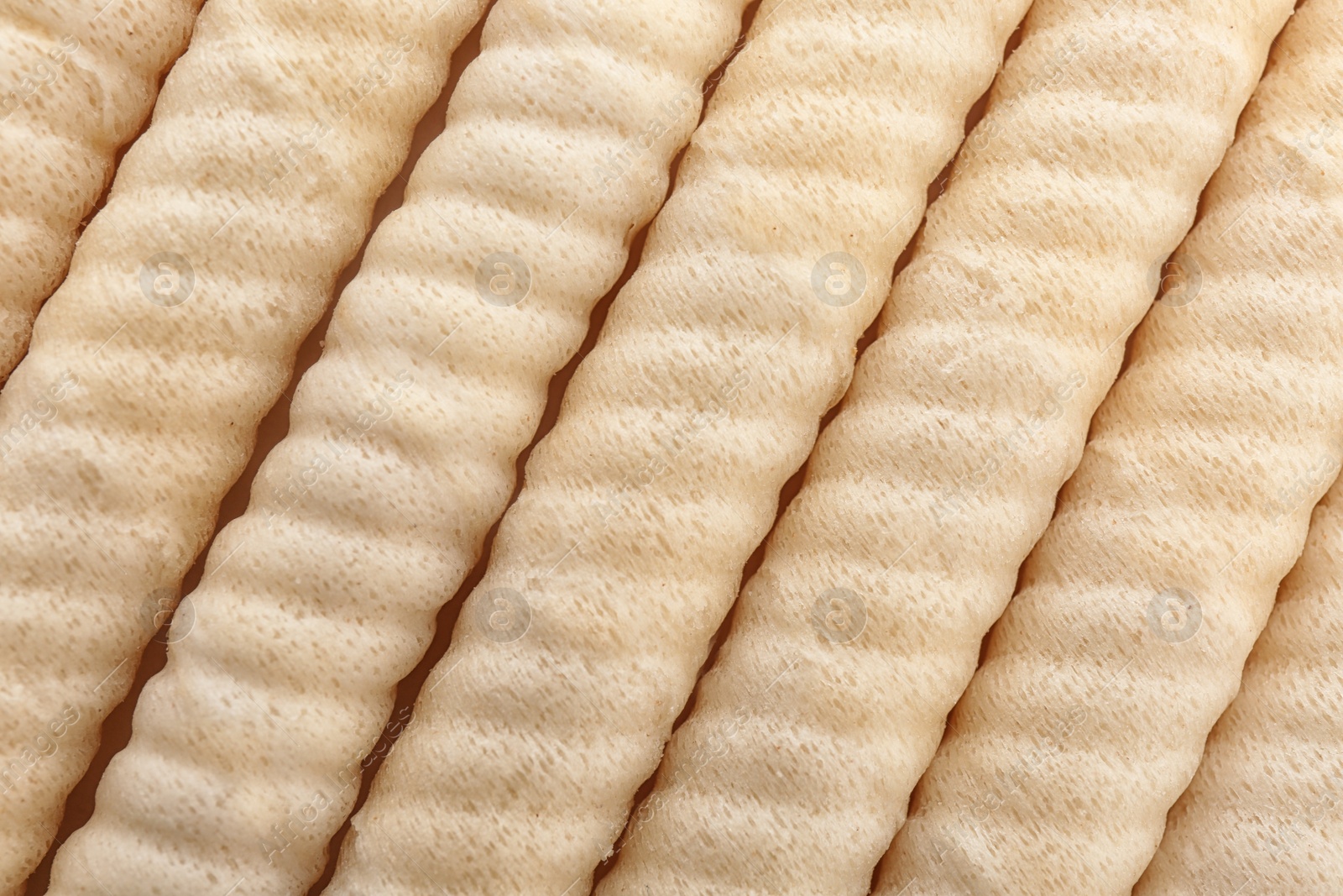 Photo of Delicious wafer rolls as background, top view. Sweet food