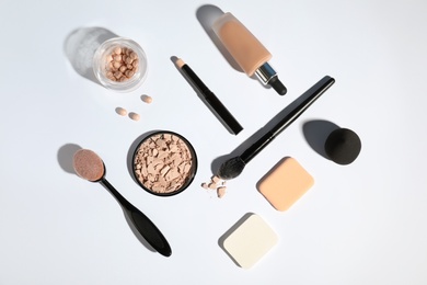 Flat lay composition with skin foundation and powder on white background