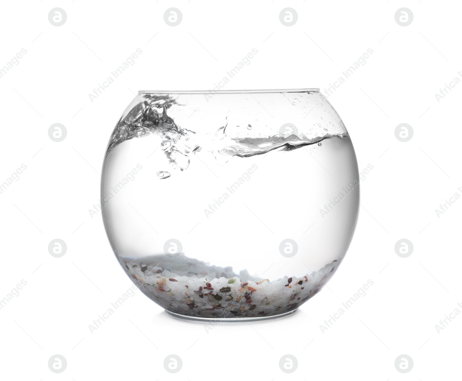 Photo of Splash of water in round fish bowl with decorative pebbles on white background