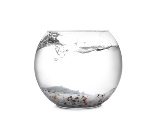 Photo of Splash of water in round fish bowl with decorative pebbles on white background