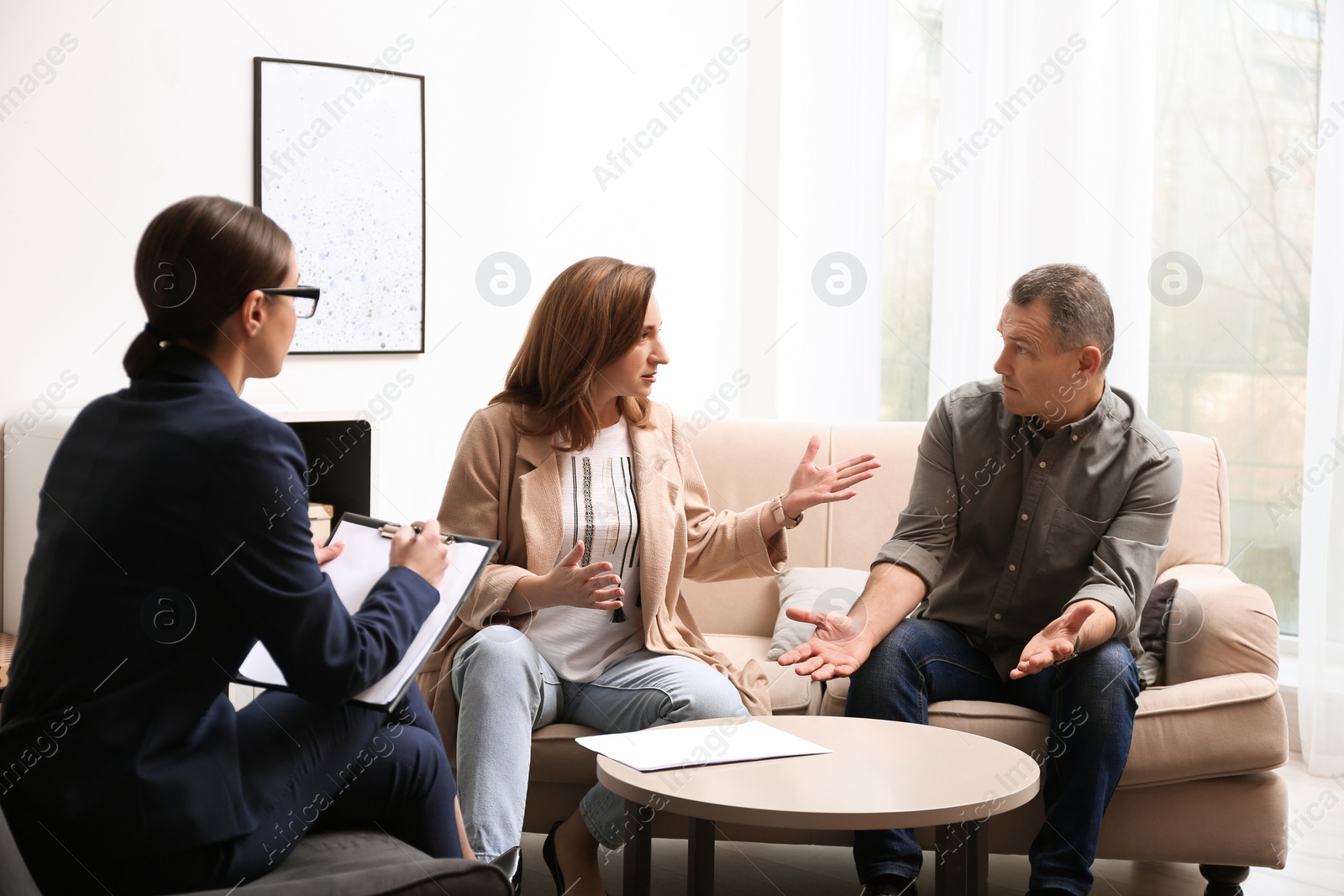 Photo of Psychotherapist working with couple in office. Family counselling