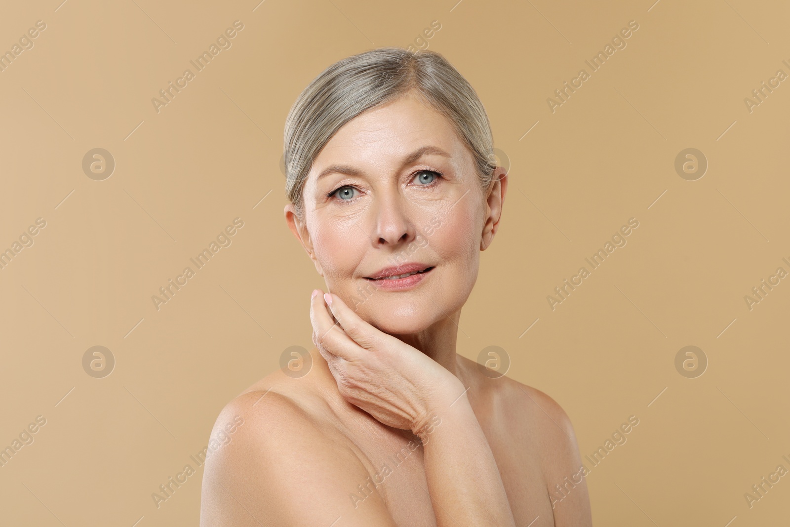 Photo of Beautiful mature woman with healthy skin on beige background