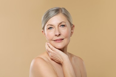 Photo of Beautiful mature woman with healthy skin on beige background