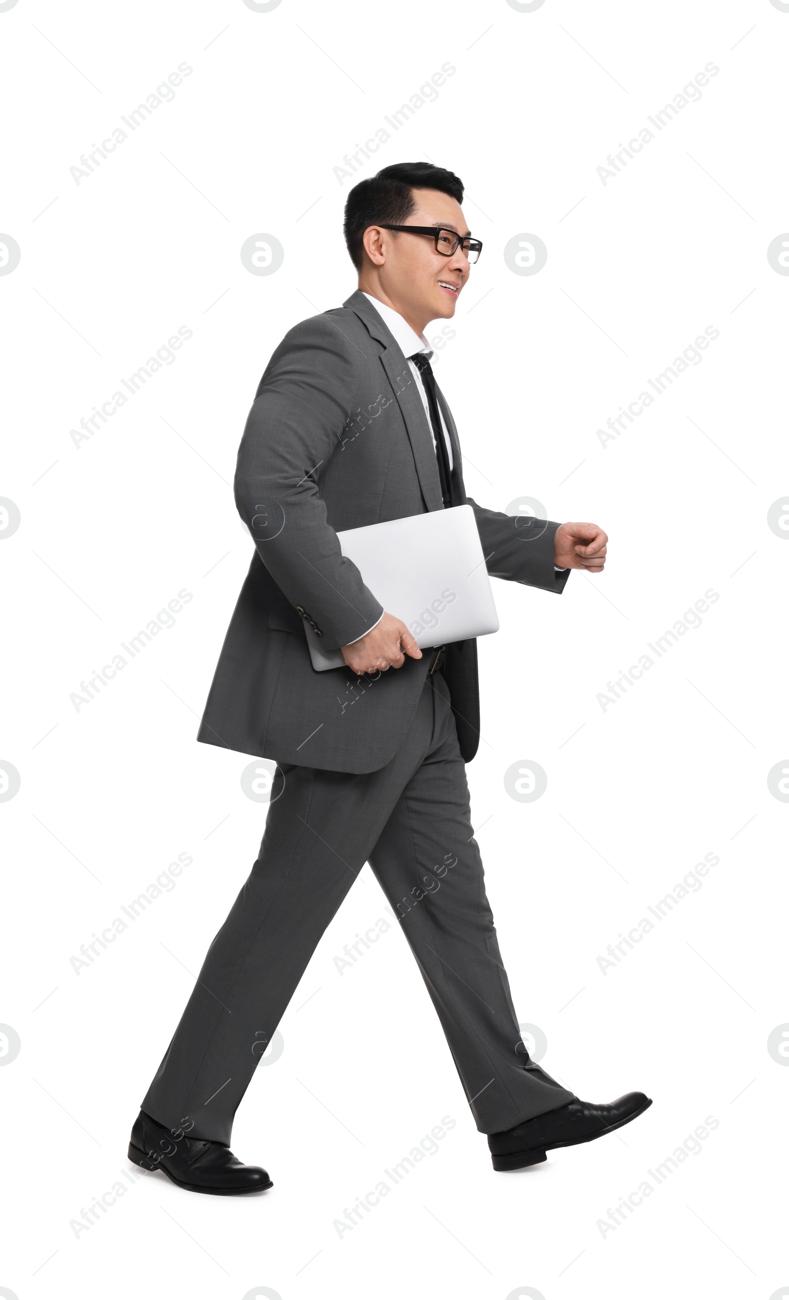 Photo of Businessman in suit with laptop walking on white background