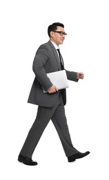 Businessman in suit with laptop walking on white background