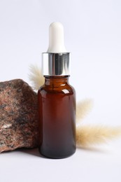 Composition with bottle of cosmetic serum on white background