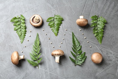 Flat lay composition with fresh champignon mushrooms on grey background