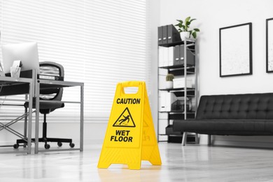 Photo of Cleaning service. Wet floor sign in office