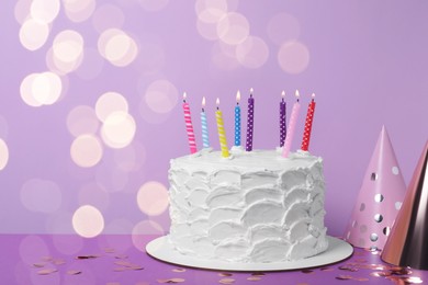 Photo of Delicious cake with burning candles and festive decor on purple background. Space for text
