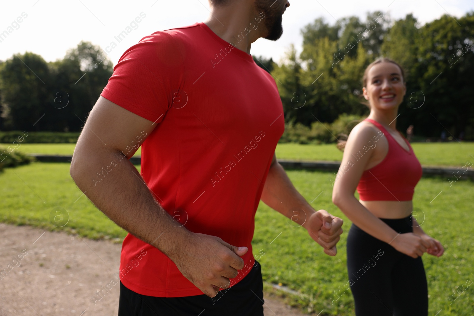 Photo of Healthy lifestyle. Couple running in park on sunny day, closeup