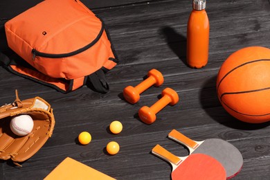 Photo of Many different sports equipment on dark grey wooden table