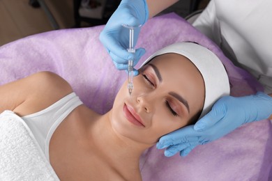 Young woman getting facial injection in beauty salon, above view. Cosmetic procedure