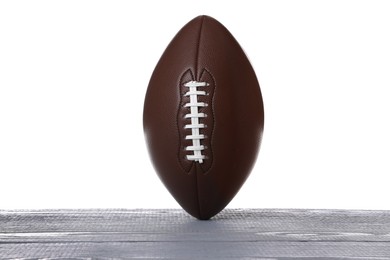 Photo of American football ball on grey wooden table against white background