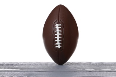 American football ball on grey wooden table against white background