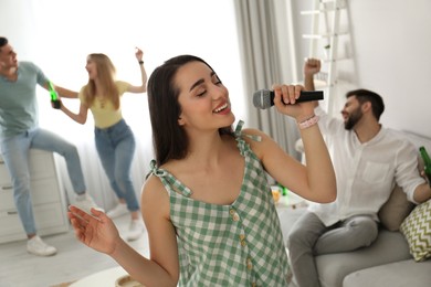 Young woman singing karaoke with friends at home