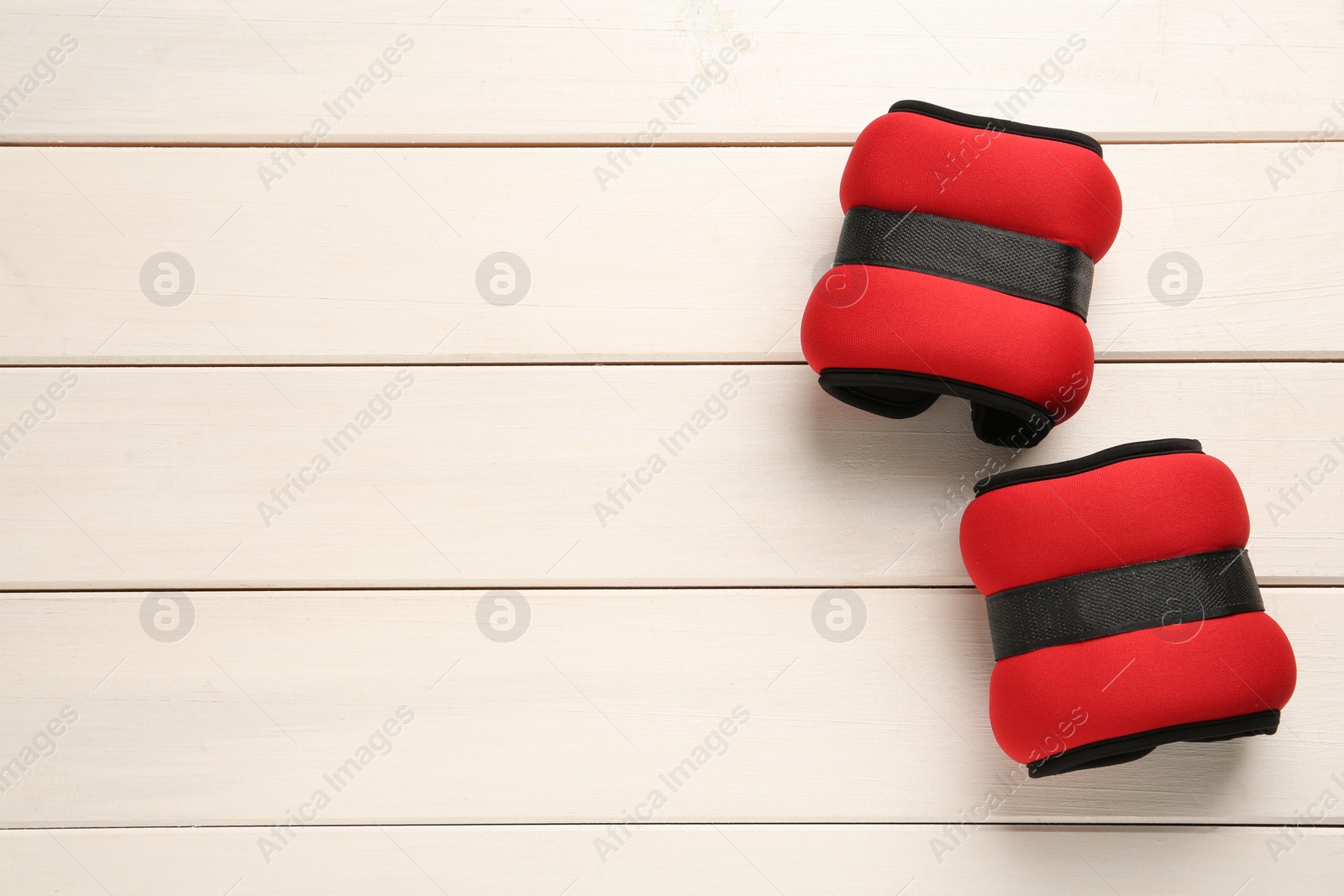 Photo of Red weighting agents on white wooden table, flat lay. Space for text