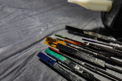 Photo of Tattoo needles covered with colorful inks on table, closeup. Space for text