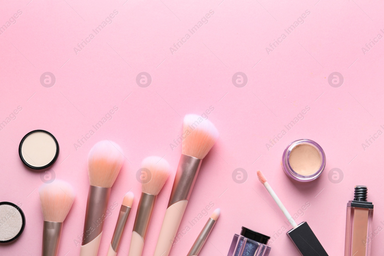 Photo of Flat lay composition with makeup brushes on pink background. Space for text