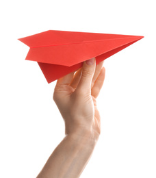 Woman holding red paper plane on white background, closeup