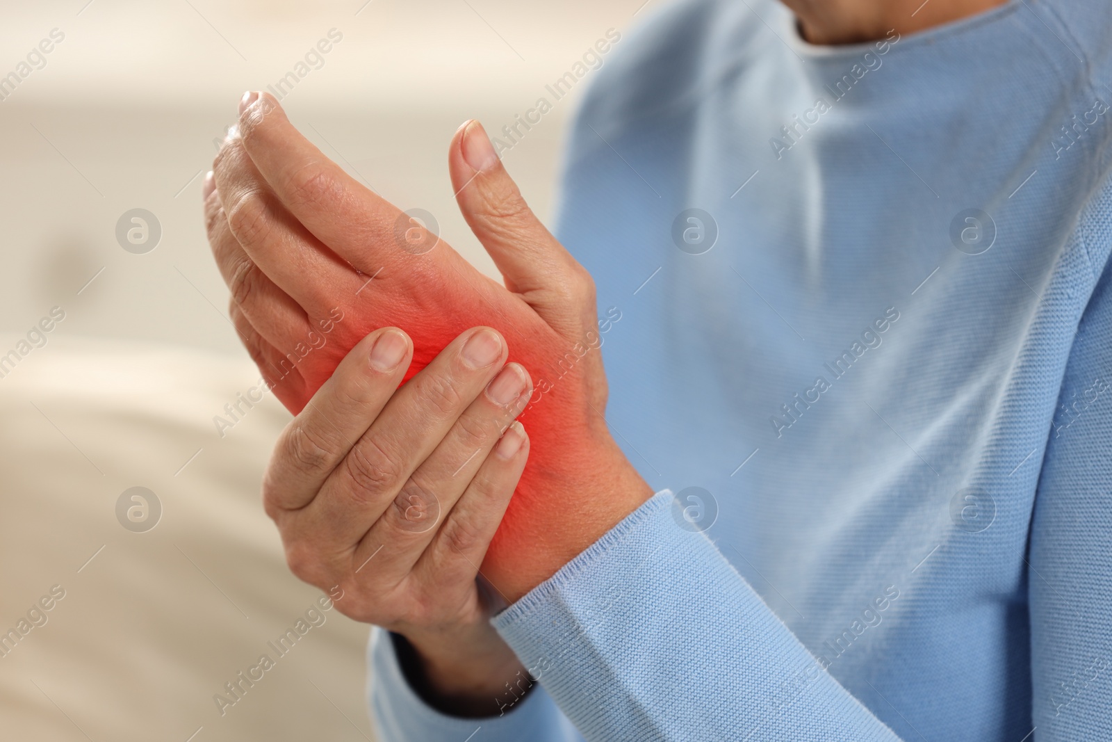 Image of Woman suffering from pain in wrist indoors, closeup